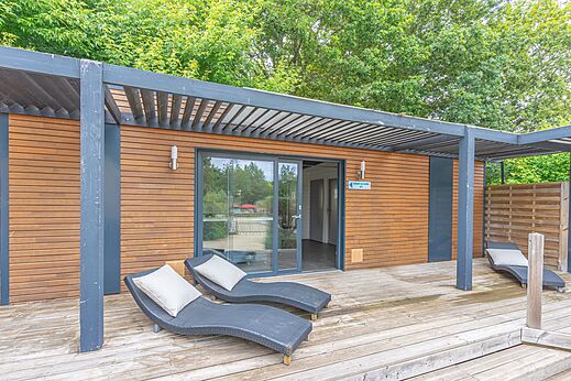 Modernes Mobilheim mit Holzterrasse und Stühlen auf dem Campingplatz CAPFUN La Chênaie in PORNIC (44).