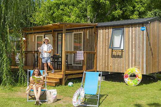 Wooden mobile home with terrace, couple on holiday at CAPFUN Chênes campsite in Medis/Royan (17).