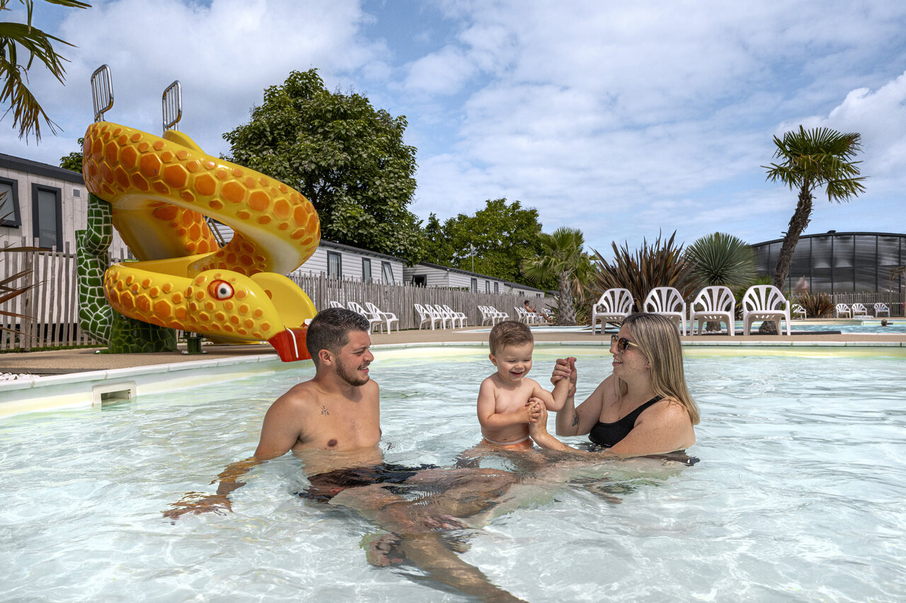Familie mit Kind genie�t Pool und Schlangenrutsche auf Campingplatz CLICOCHIC Chevaliers in HOULGATE (14).