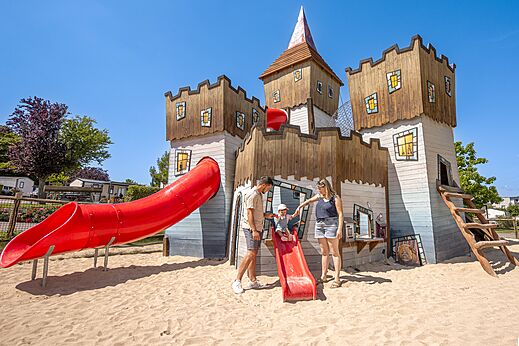 Speelkasteel met rode glijbanen op camping CLICOCHIC Chevaliers in HOULGATE (14).