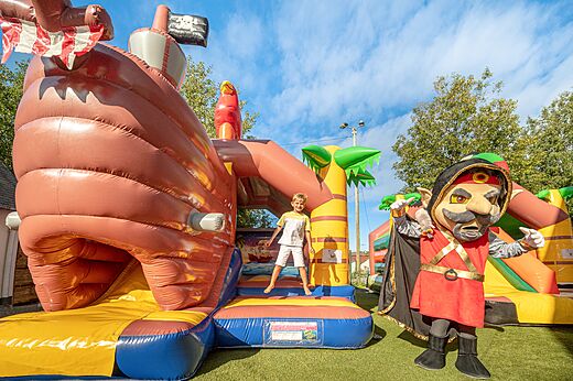 Inflatable pirate ship and child playing at CLICOCHIC Chevaliers campsite in HOULGATE (14).
