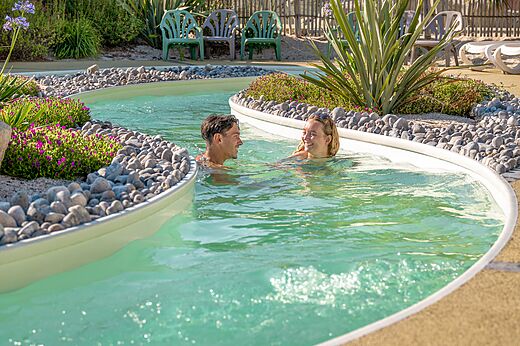Schwimmbad Lazy River mit l�chelndem Paar auf dem Campingplatz CLICOCHIC Chouans in SAINT HILAIRE DE RIEZ (85).