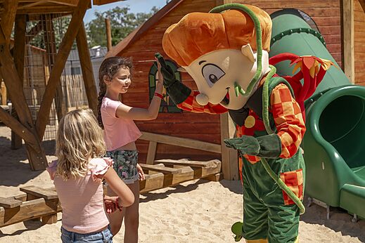 Maskottchen und Kinder auf dem Spielplatz des Campingplatzes CLICOCHIC Chouans.