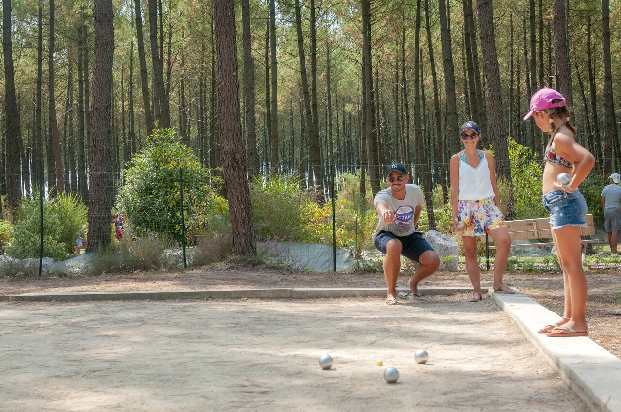 Family playing p�tanque on shaded court at VAGUES OCEANES Les Cigales in Moliets-Plage (40).
