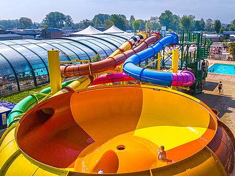 Colorful water slides and outdoor swimming pool at CAPFUN Citadelle de Loustic campsite in Hermanville sur Mer.