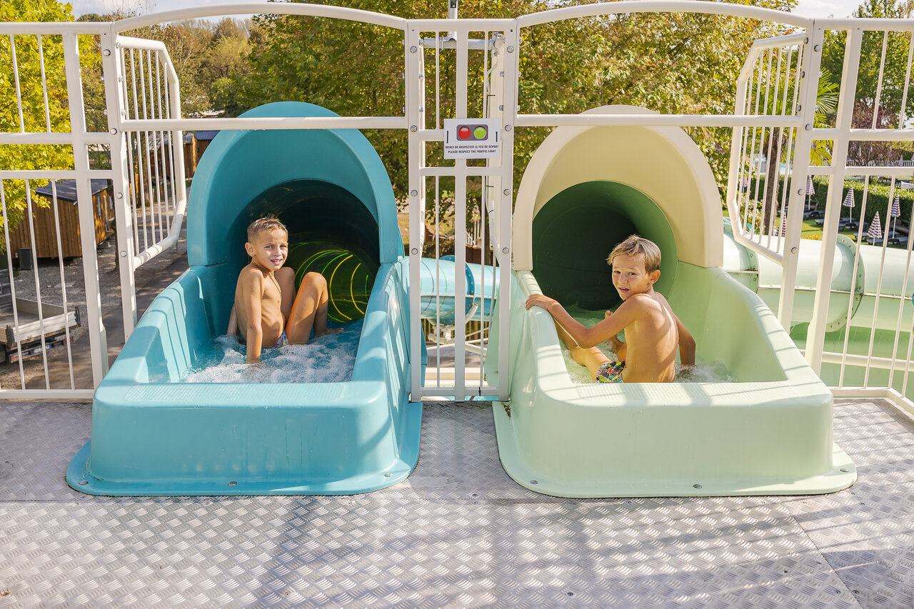Wasserrutschen mit lachenden Kindern auf dem Campingplatz CAPFUN Citta di Angera VA.