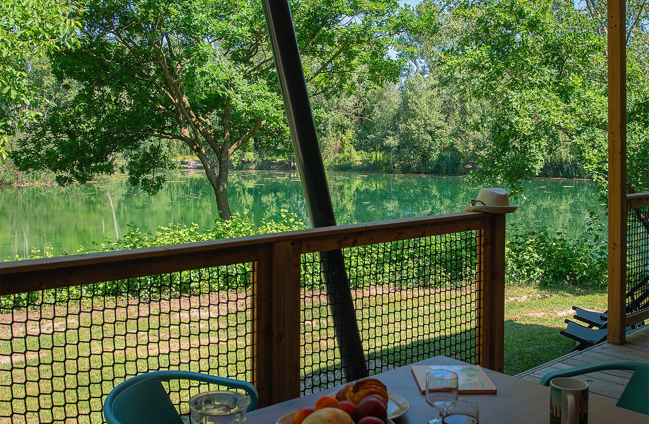 Terrasse der Unterkunft mit Seeblick auf dem Campingplatz CLICOCHIC Au Clair Ruisseau in Gerstheim.