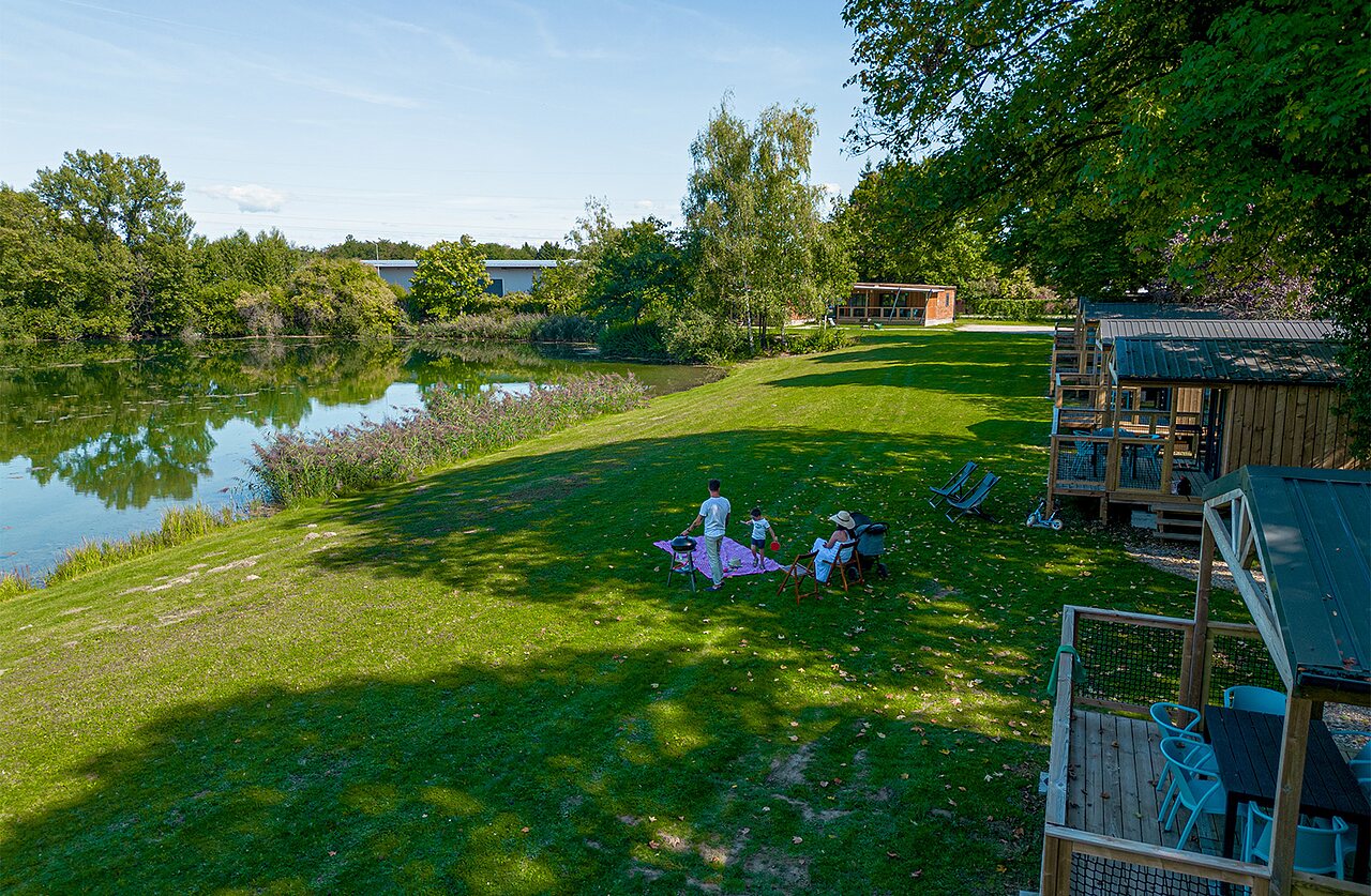 Holzh�tten, See und Familie beim Picknick auf Camping CLICOCHIC Au Clair Ruisseau.