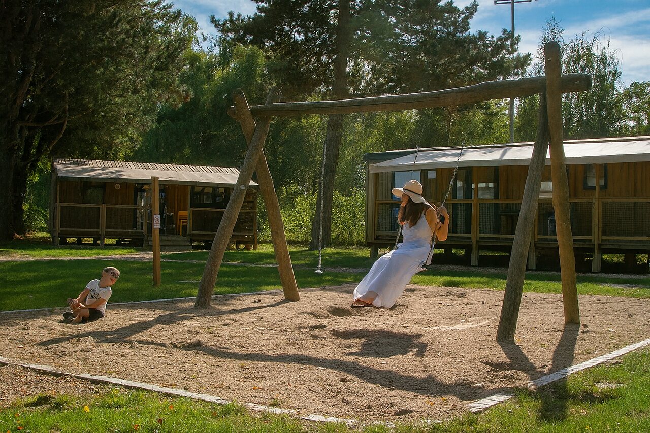 Holzschaukel, Spielplatz und Mobilheime auf Camping CLICOCHIC Au Clair Ruisseau in Gerstheim (67).