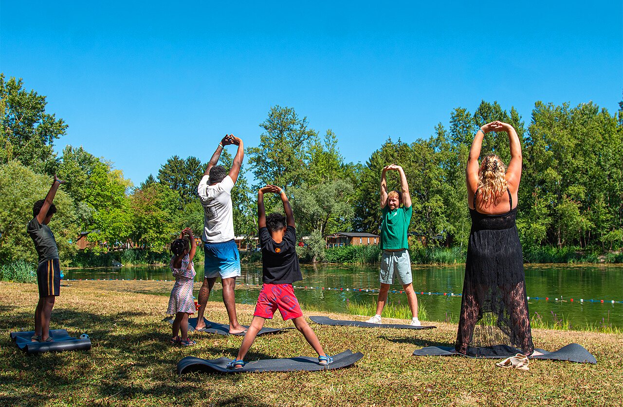 Fitness animatie in groep bij het meer op camping CLICOCHIC Au Clair Ruisseau in Gerstheim (67).