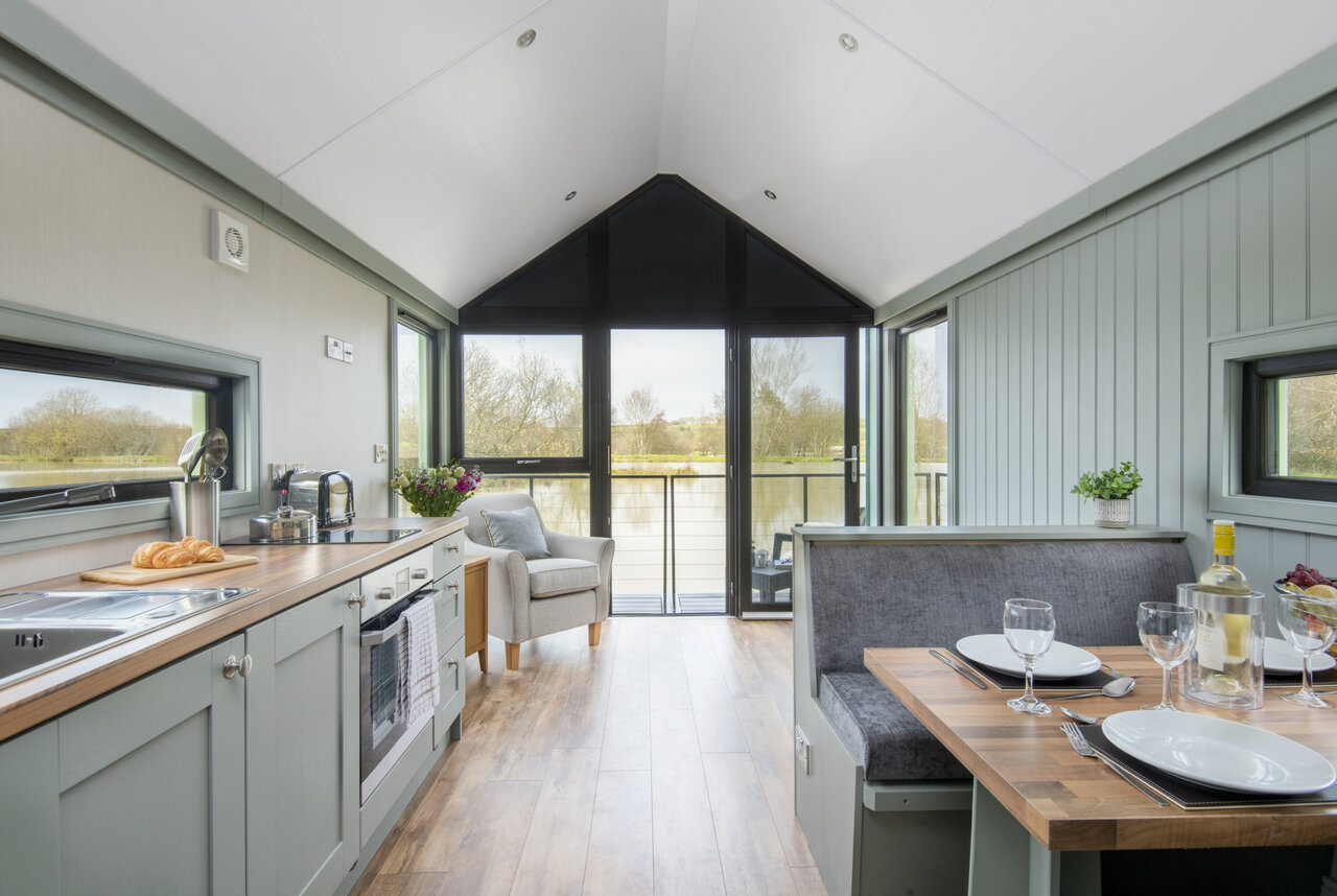 Cocina equipada, comedor, vista al lago en el camping CAPFUN UK Clawford Lakes.