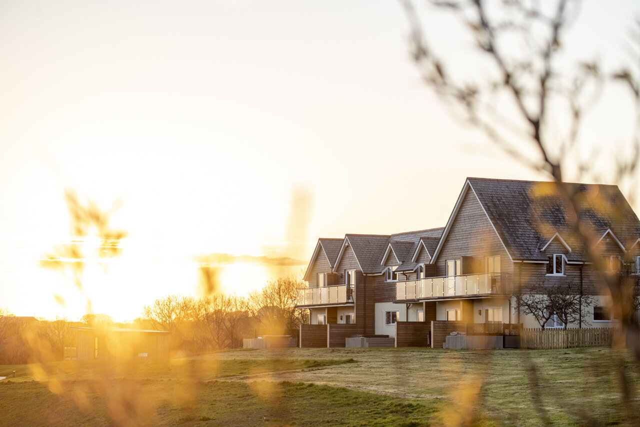Alojamientos modernos con balcones al atardecer en el camping CAPFUN UK Clawford Lakes.