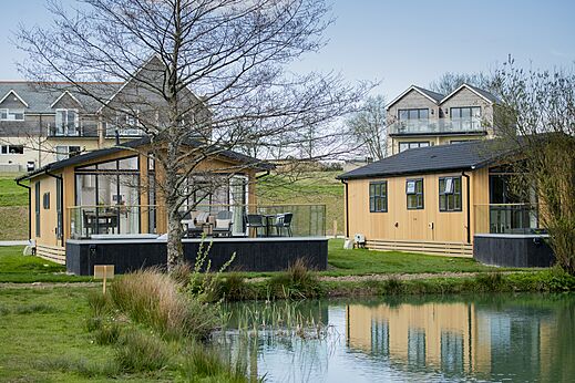 Modern mobile homes with terrace near water at CAPFUN UK Clawford Lakes.