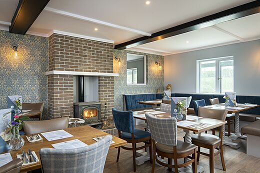 Innenrestaurant mit Kamin und Tischen auf dem Campingplatz CAPFUN UK Clawford Lakes in Clawton, Holsworthy.