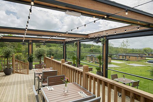 Außenrestaurantterrasse mit Tischen auf CAPFUN UK Clawford Lakes.