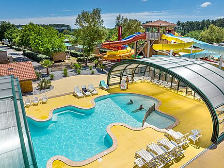Überdachtes Schwimmbad und bunte Wasserrutschen auf dem Campingplatz CAPFUN Clown Océan in TOSSE (40).