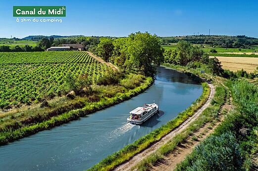 Boot f�hrt auf dem Canal du Midi, umgeben von Weinbergen und Natur.