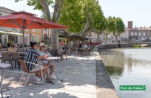 Couple déjeunant en terrasse au bord du Canal du Midi, Port de Trèbes (Aude).