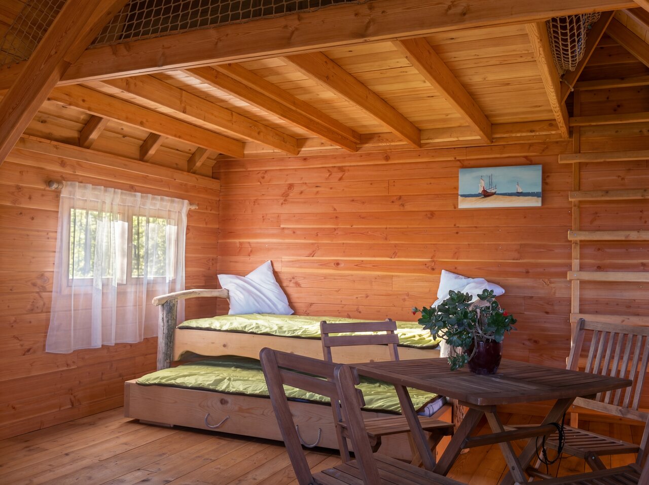 Innenansicht Holzh�tte mit Ausziehbetten und Tisch auf dem Campingplatz CAPFUN C�te Vermeille: Cabane dans les airs in Port La Nouvelle (11).