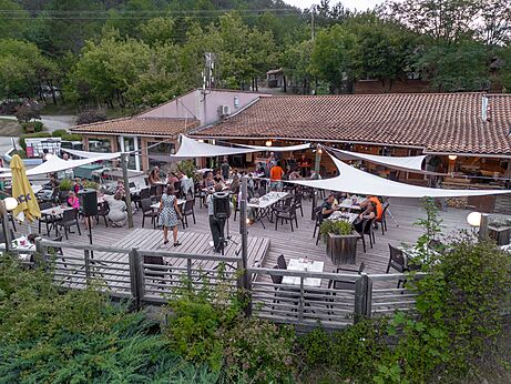 Belebte Restaurantterrasse mit Abendunterhaltung auf dem Campingplatz CLICOCHIC Couriou in Recoubeau-Jansac.