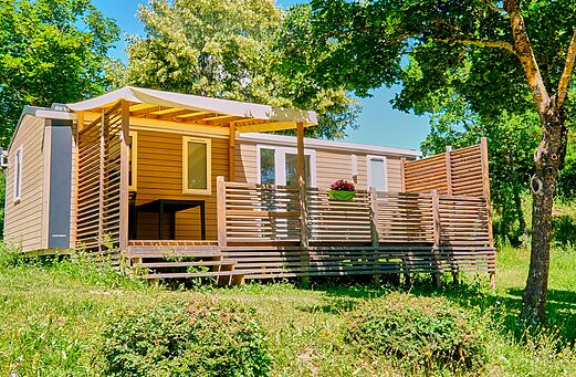 Modernes Mobilheim mit schattiger Terrasse auf dem Campingplatz CLICOCHIC Couriou in Recoubeau-Jansac.