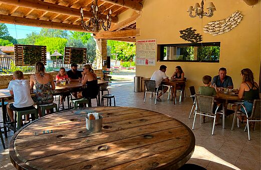 Überdachter Restaurant- und Barbereich mit Familien auf dem Camping CLICOCHIC Coutelière (84).