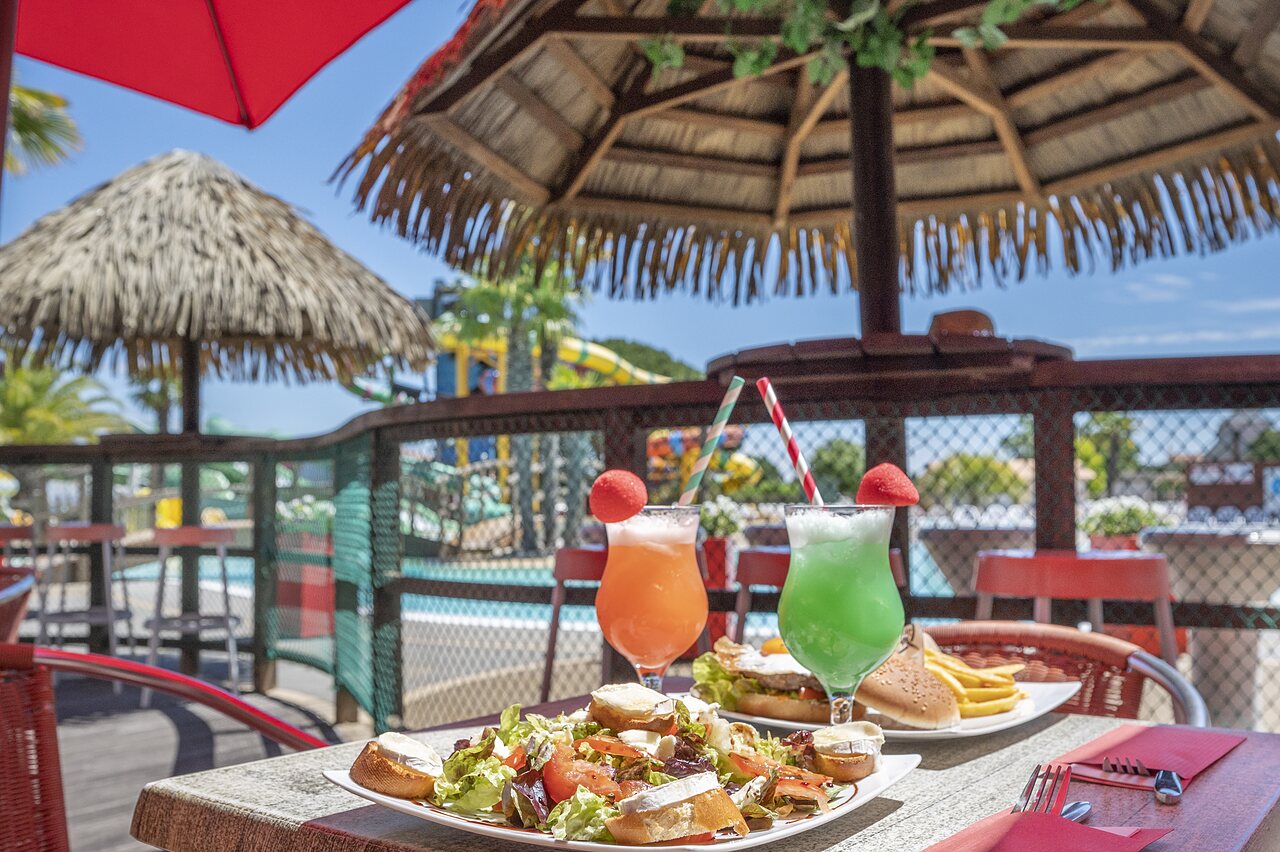 Speisen und Cocktails auf der Restaurantterrasse mit Pool auf dem Campingplatz CAPFUN Curty's in Jard sur Mer (85).