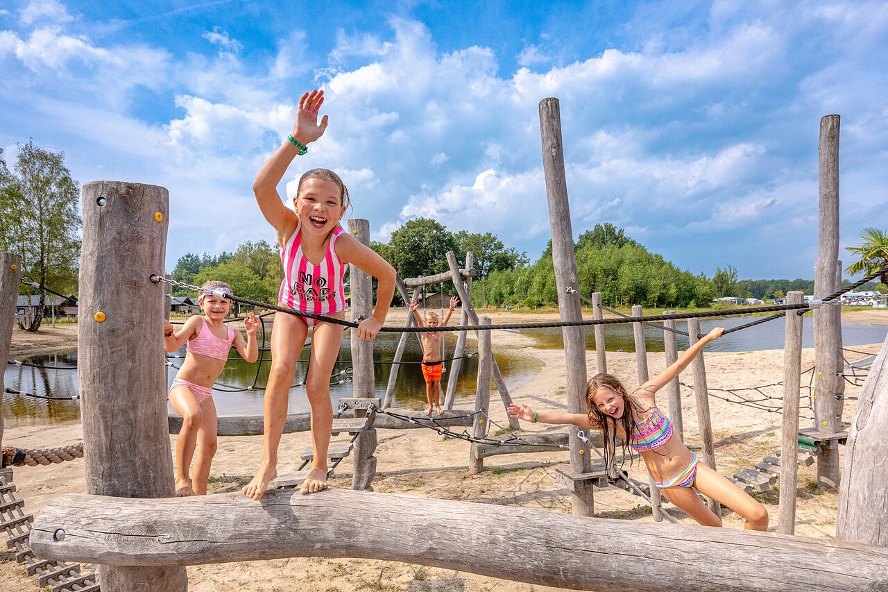 Kinder auf Holzspielplatz, Sandstrand am Campingplatz CAPFUN De Belten in Rheeze.