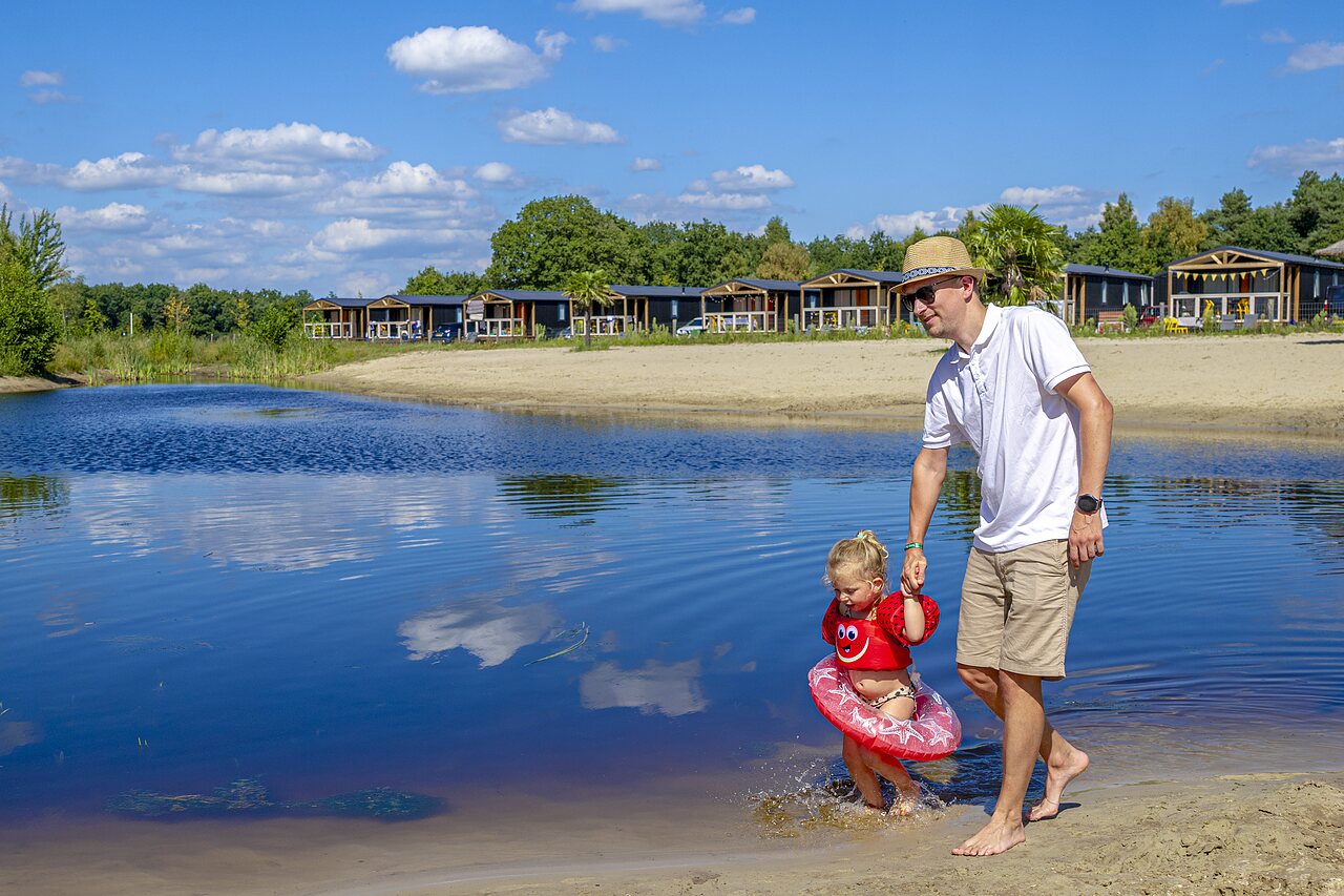 Vater und Kind im See, Strand und Unterk�nfte auf dem Campingplatz CAPFUN De Belten in Rheeze.
