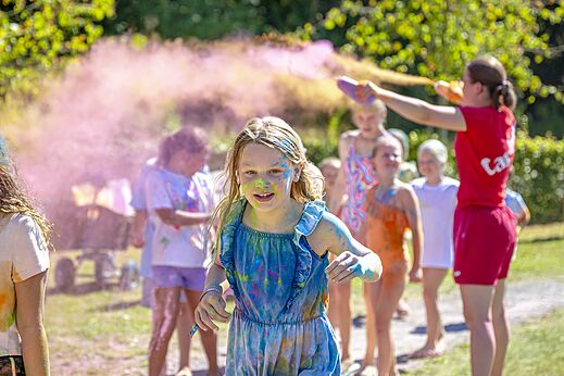 Fröhliche Kinder bei einer Farbpulver-Aktivität auf dem Campingplatz CAPFUN De Belten in Rheeze.