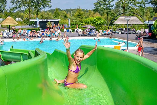 Groene waterglijbaan en buitenzwembad op camping CAPFUN De Belten in Rheeze.