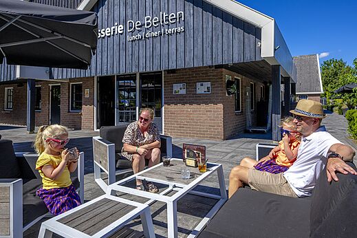 Familie genießt die Brasserie-Terrasse auf dem Campingplatz CAPFUN De Belten in Rheeze.