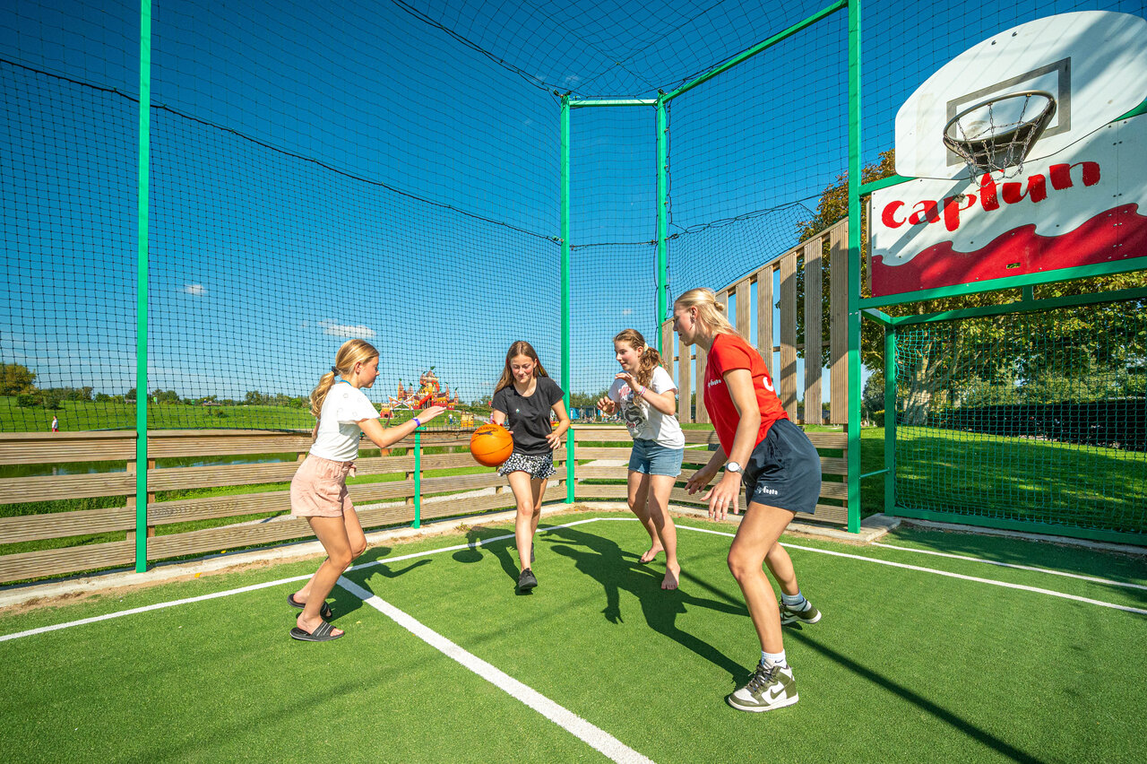 M�dchen spielen Basketball auf Multisportplatz auf dem Campingplatz CAPFUN De Bongerd in Tuitjenhorn.