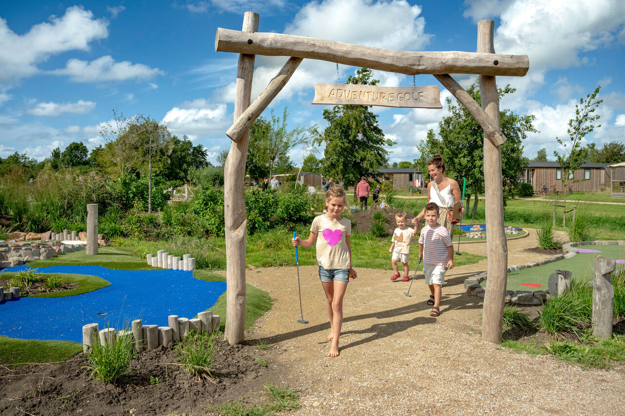 Familie spielt Abenteuergolf auf einem unterhaltsamen Parcours auf dem Campingplatz CAPFUN De Bongerd in Tuitjenhorn.