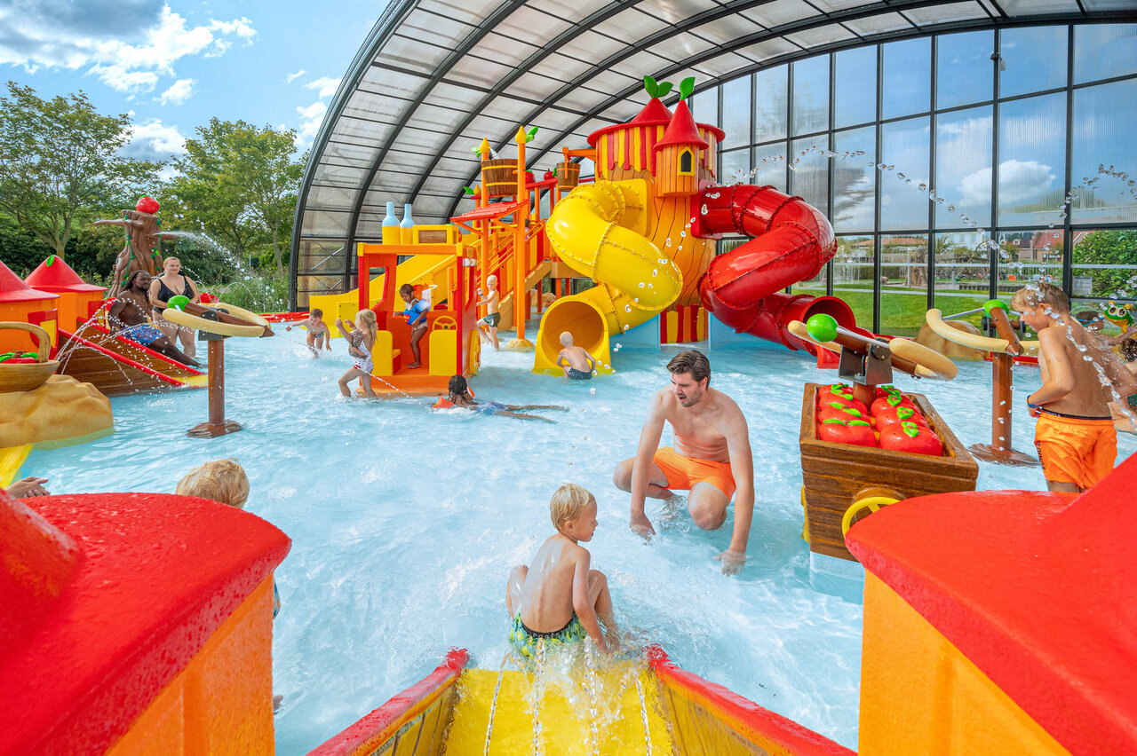 �berdachter Wasserpark mit bunten Rutschen und spielenden Kindern auf dem Campingplatz CAPFUN De Bongerd in Tuitjenhorn.