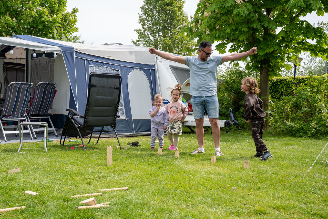 Familie spielt Kubb auf dem Campingplatz CAPFUN De Bongerd in Tuitjenhorn.