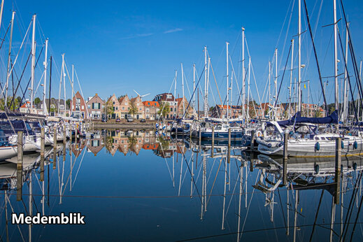 Jachthaven met zeilboten en historische huizen in Medemblik, Nederland.