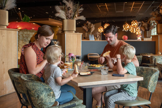 Lächelnde Familie beim Mittagessen im Restaurant des Campingplatzes CAPFUN De Bongerd in Tuitjenhorn.