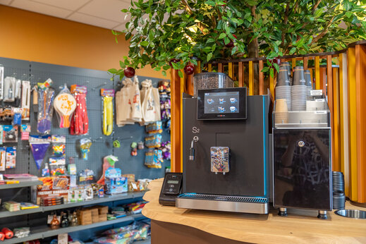 Koffiezetapparaat en schappen van de supermarkt op camping CAPFUN De Bongerd in Tuitjenhorn.
