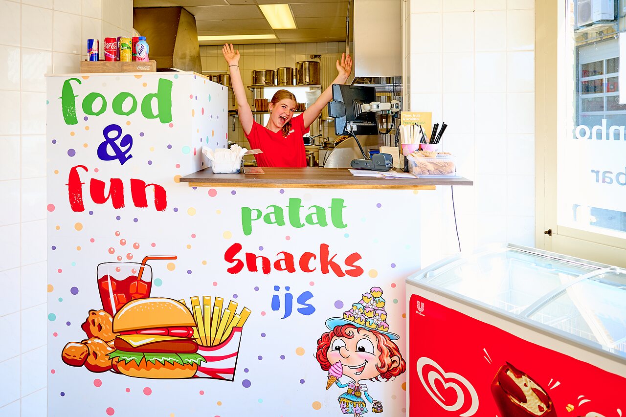 Bunter Imbissstand mit l�chelnder Mitarbeiterin, Pommes und Eiscreme auf dem Campingplatz CAPFUN De Eikenhof in Paasloo/Oldemarkt.