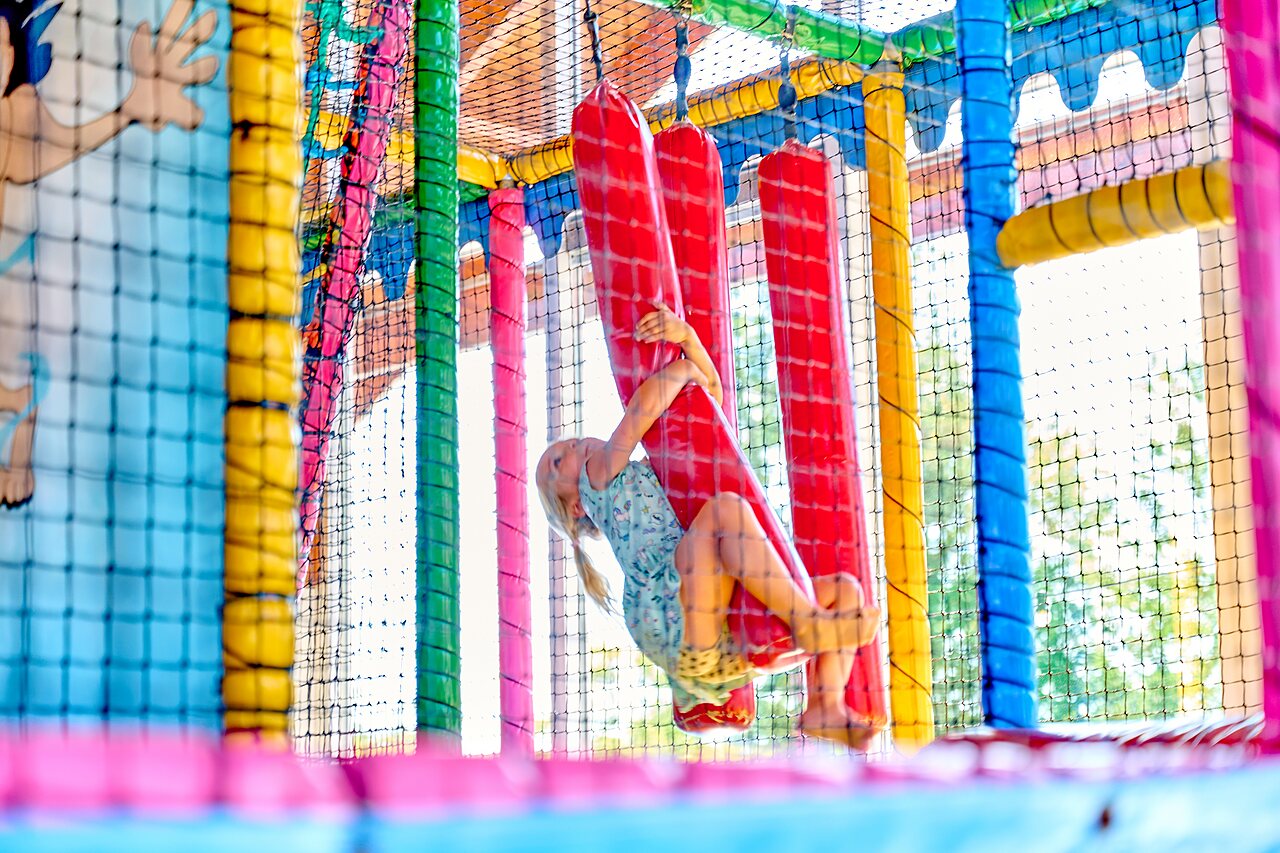 Kind spielt in der Indoor-Spielstruktur auf Camping CAPFUN De Eikenhof in Paasloo/Oldemarkt.