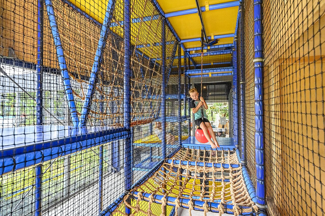 Kind auf Schaukel, Indoor-Spielplatz, CAPFUN De Pekelinge, Oostkapelle.