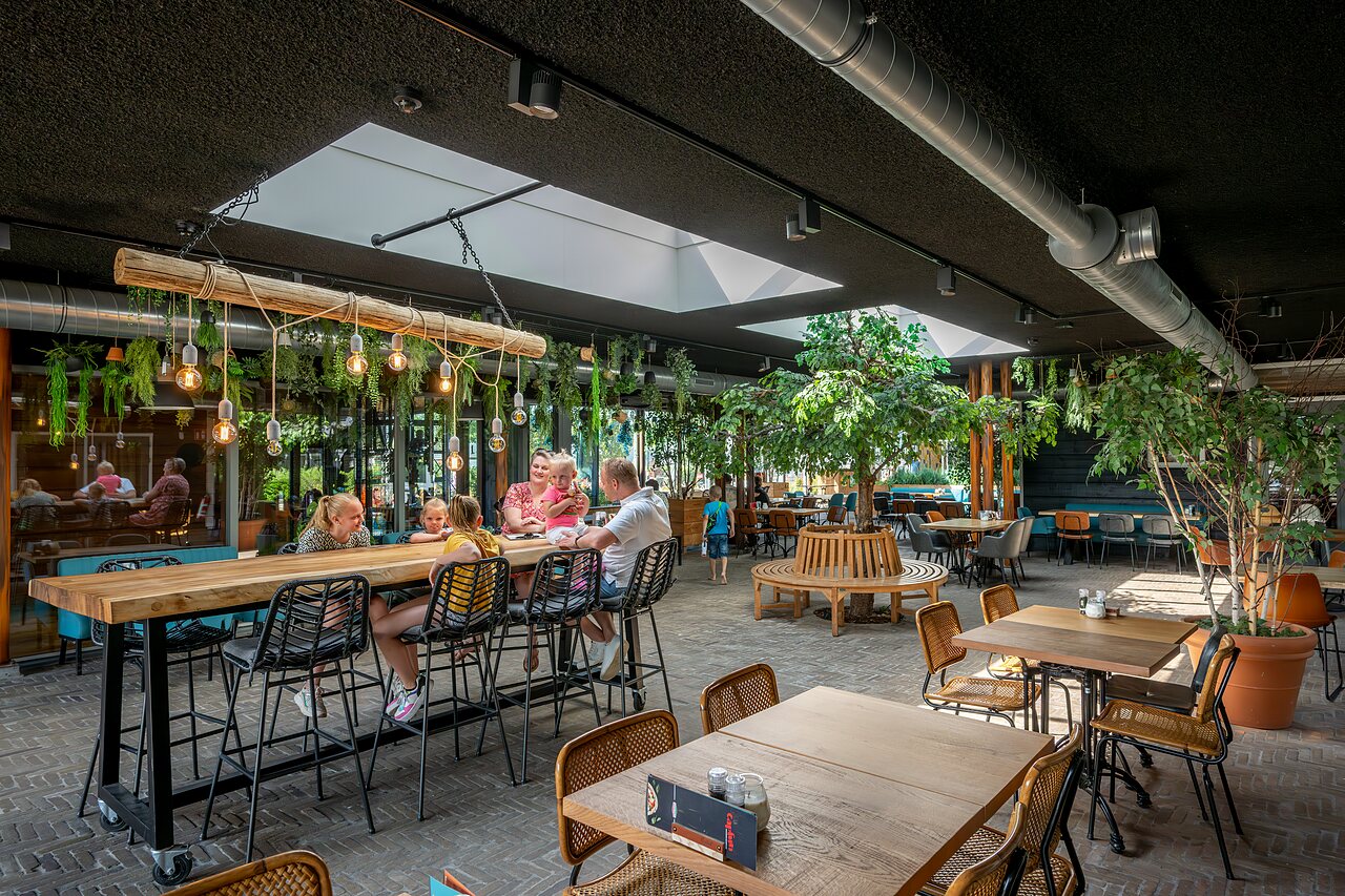 Modernes Restaurant mit Familien und Pflanzen-Dekor auf dem Campingplatz CAPFUN De Pekelinge in Oostkapelle.