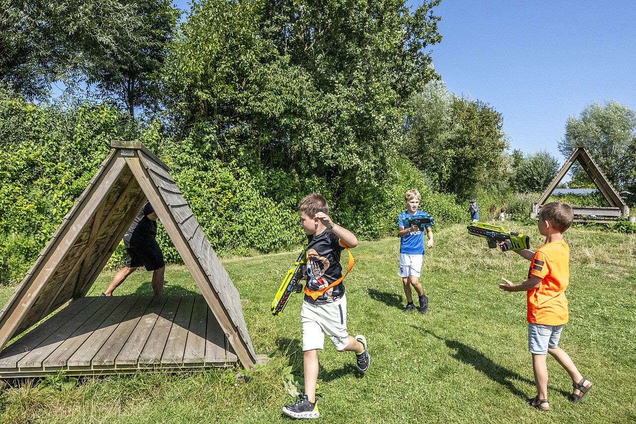 Kinder spielen Laser-Tag im Freien auf dem Campingplatz CAPFUN De Pekelinge in Oostkapelle.