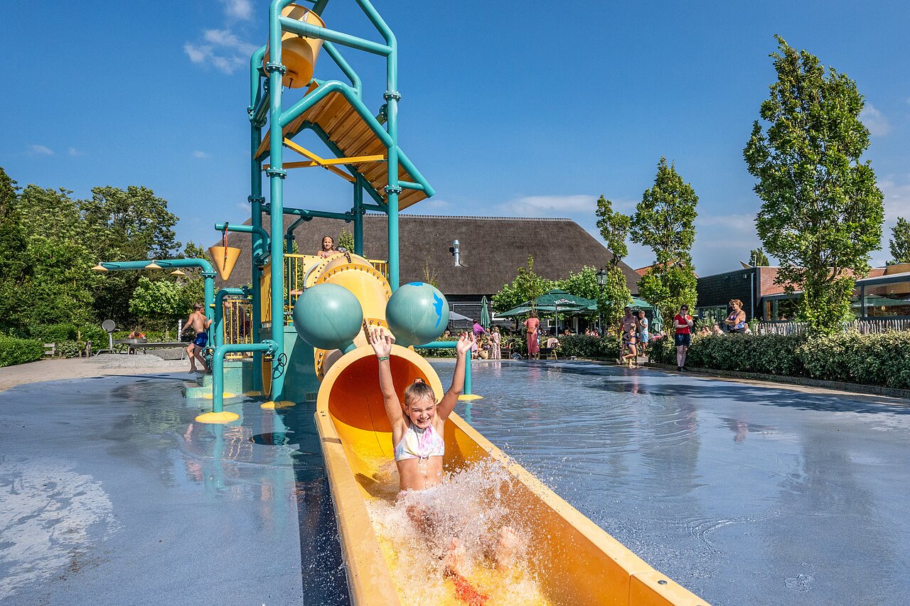 Kind auf Wasserrutsche, Wasserspielplatz am CAPFUN De Pekelinge Campingplatz in Oostkapelle.
