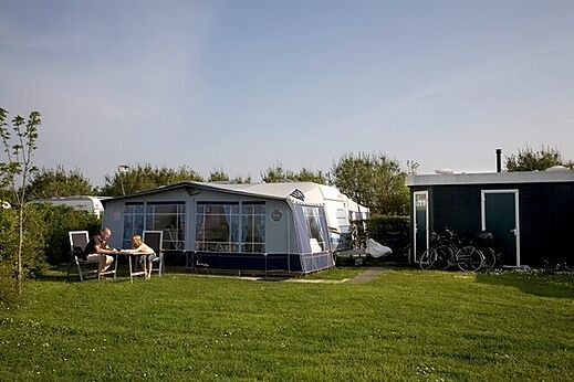 Wohnwagen mit Vorzelt und gr�nem Stellplatz auf Campingplatz CAPFUN De Pekelinge in Oostkapelle.