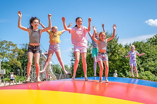 Enfants sautant sur coussin gonflable coloré, camping CAPFUN De Pekelinge à Oostkapelle.