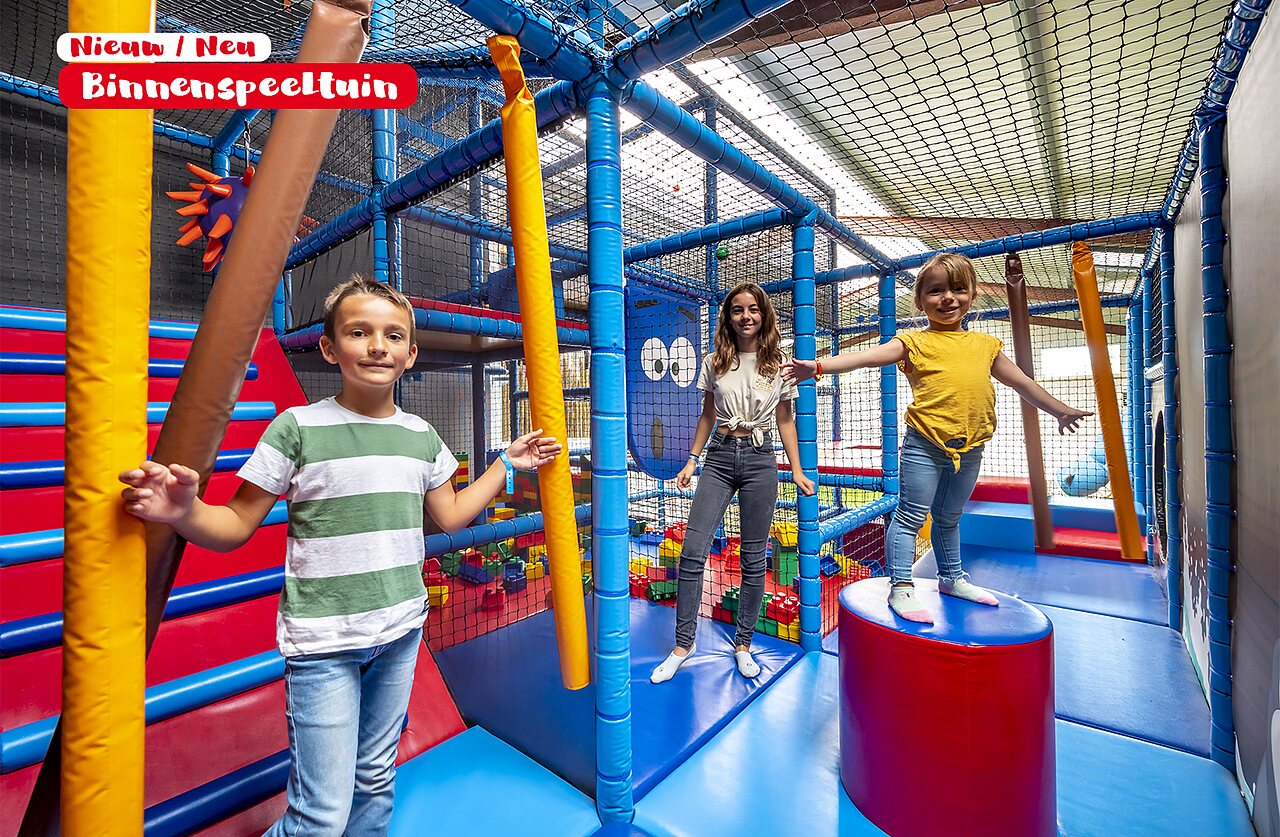 Aire de jeux int�rieure color�e avec enfants souriants au camping CAPFUN De Rotonde � Enspijk.