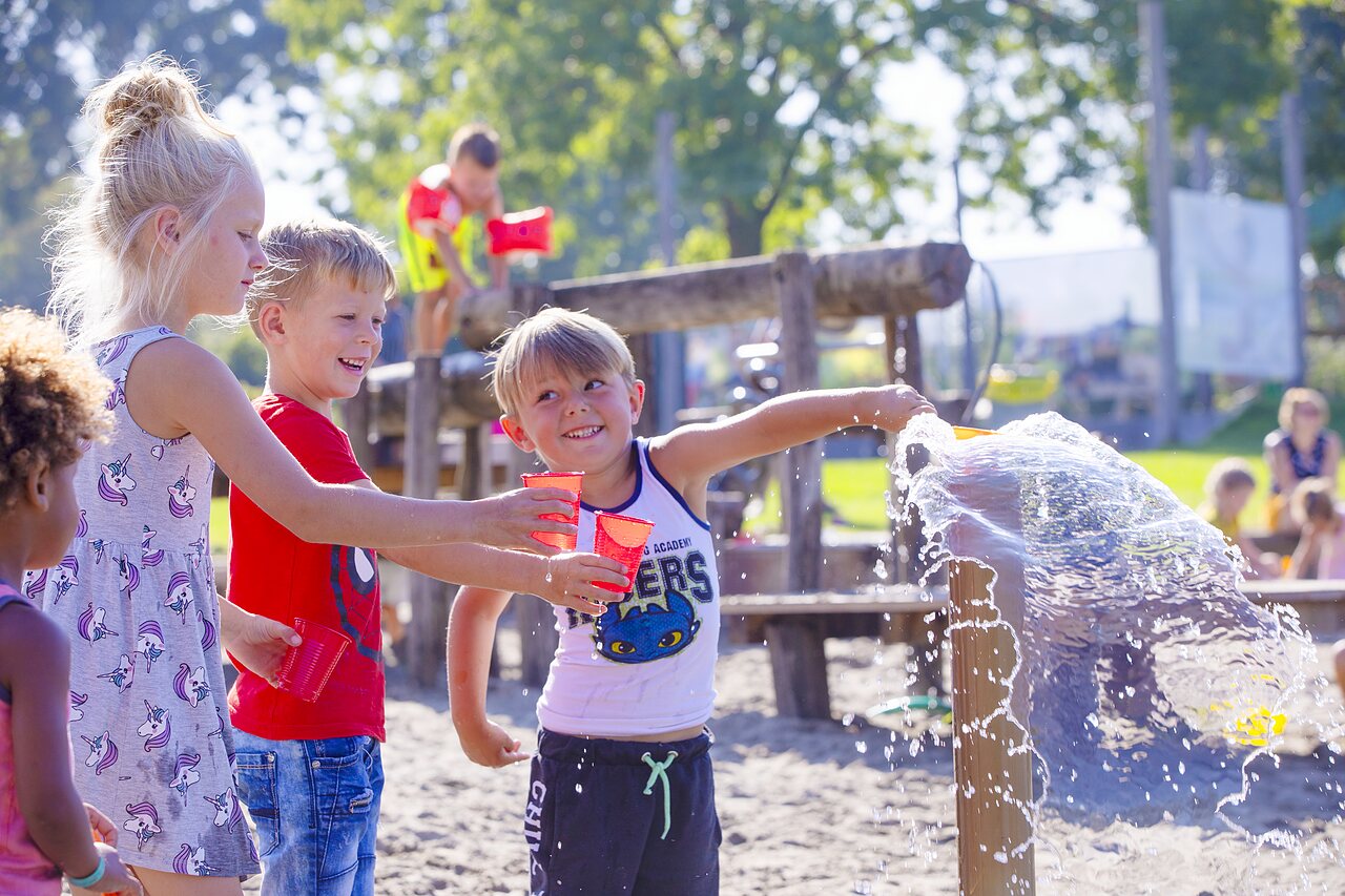 Enfants s'amusant avec l'eau dans l'aire de jeux au camping CAPFUN De Rotonde � Enspijk.