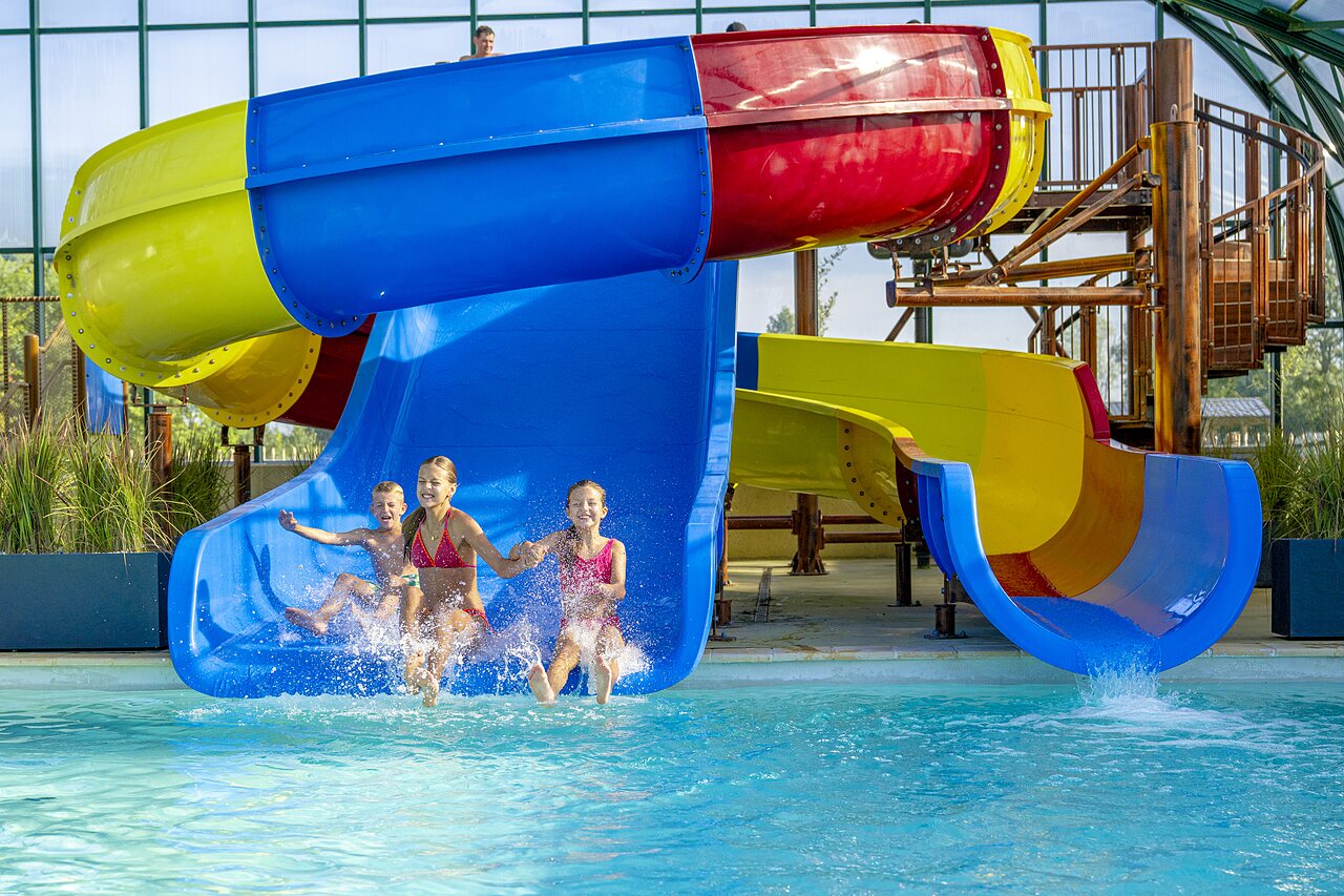 Toboggans aquatiques et piscine avec enfants rieurs au camping CAPFUN De Rotonde � Enspijk.